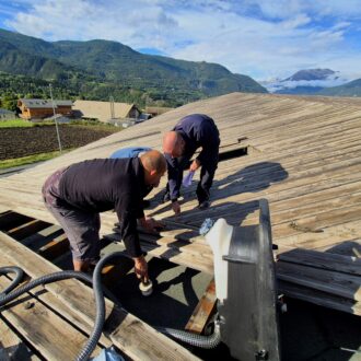 Trois hommes sur un toit en mélèze.
