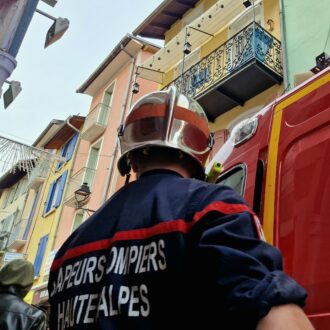 Un pompier casque sur la tête remonte dans son camion-ambulance