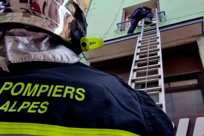 Deux sapeurs-pompiers. L'un est en bas d'un immeuble, l'autre monte à l'échelle. - Agrandir l'image 5 sur 5, fenêtre modale