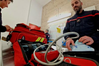 Deux sapeurs-pompiers vérifient leur matériel de premier secours. - Agrandir l'image 2 sur 5, fenêtre modale