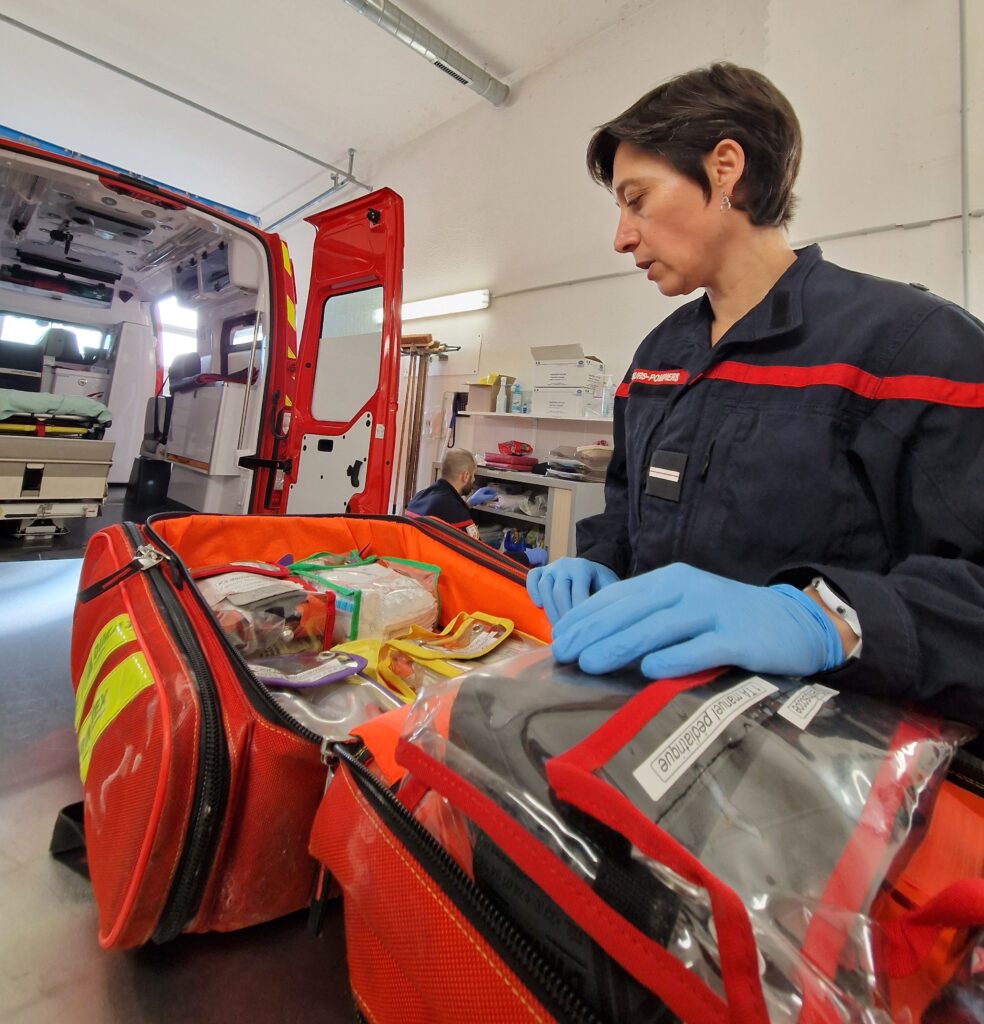 Une femme pompier vérifie un sac de première intervention. - Agrandir l'image, fenêtre modale