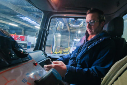Un homme assis dans la cabine d'un camion de déneigement. - Agrandir l'image, fenêtre modale