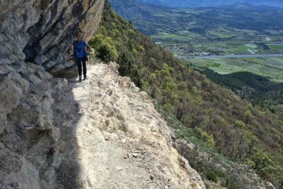 Une femme en train de randonner sur un chemin escarpé au pied d'un falaise d'escalade. - Agrandir l'image, fenêtre modale