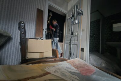 Une femme en train de porter une chaise. - Agrandir l'image 1 sur 11, fenêtre modale