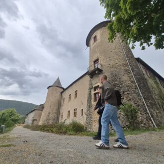Deux agents du Cedra en train de marcher devant le château de Montmaur.