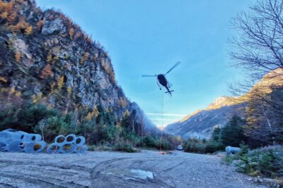 Un hélicoptère en train d'atterrie sur une zone de chantier, en fond des montagnes - Agrandir l'image 17 sur 27, fenêtre modale