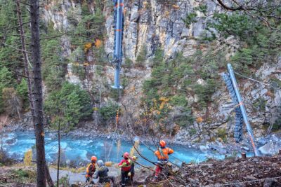 Des ouvriers en train de réceptionner un poteau héliporter en plein montagne. - Agrandir l'image 14 sur 27, fenêtre modale
