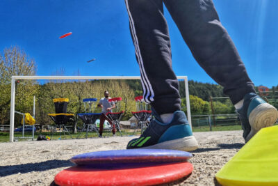 Les pieds d'un jeunes de dos en train d'envoyer des frisbee dans des paniers. - Agrandir l'image 5 sur 12, fenêtre modale