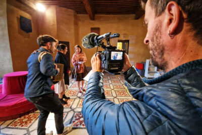 Un hommes est entrain de filmer deux chanteuse et un accordéoniste. - Agrandir l'image 10 sur 12, fenêtre modale