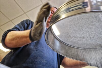 Un agent du département passe du sel routier au tamis. - Agrandir l'image 3 sur 8, fenêtre modale