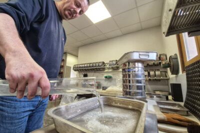 Un agent du département, verse de l'eau sur du sel routier au sein de laboratoire routier du Département. - Agrandir l'image 1 sur 8, fenêtre modale
