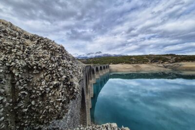 Un ancien pont ferroviaire émerge des eaux turquoise du lac de Serre-Ponçon pour le plus grand bonheur de promeneurs qui quelques semaines par an peuvent le traverser de part en part. - Agrandir l'image 1 sur 3, fenêtre modale