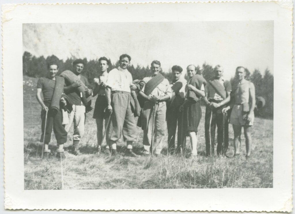 sur une photo en noir et blanc, neufs hommes assez jeunes. Certains portent des pantalons bouffants, style années 1940, chemise en coton clair, souliers en cuir, canne ou bâton en main. D'autre son en short torse nus. Tous posent fièrement. - Agrandir l'image, fenêtre modale
