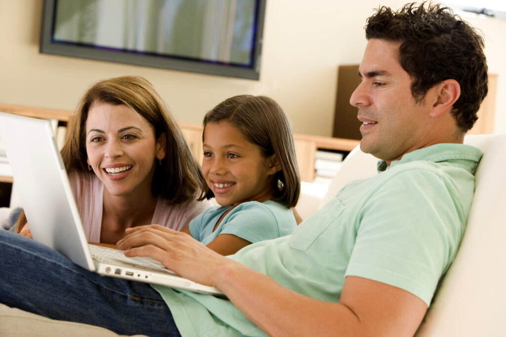 Des parents et leur fille devant un ordinateur - Agrandir l'image, fenêtre modale