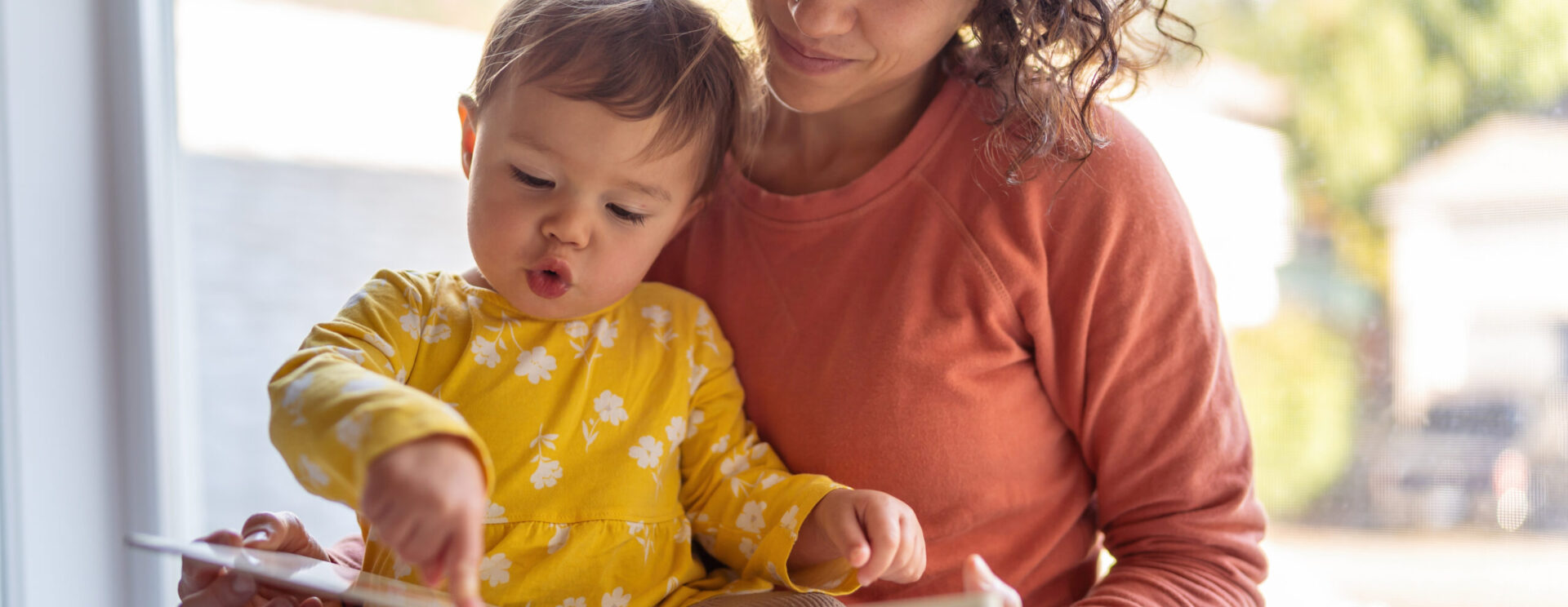 Femme lisant un livre à un enfant.