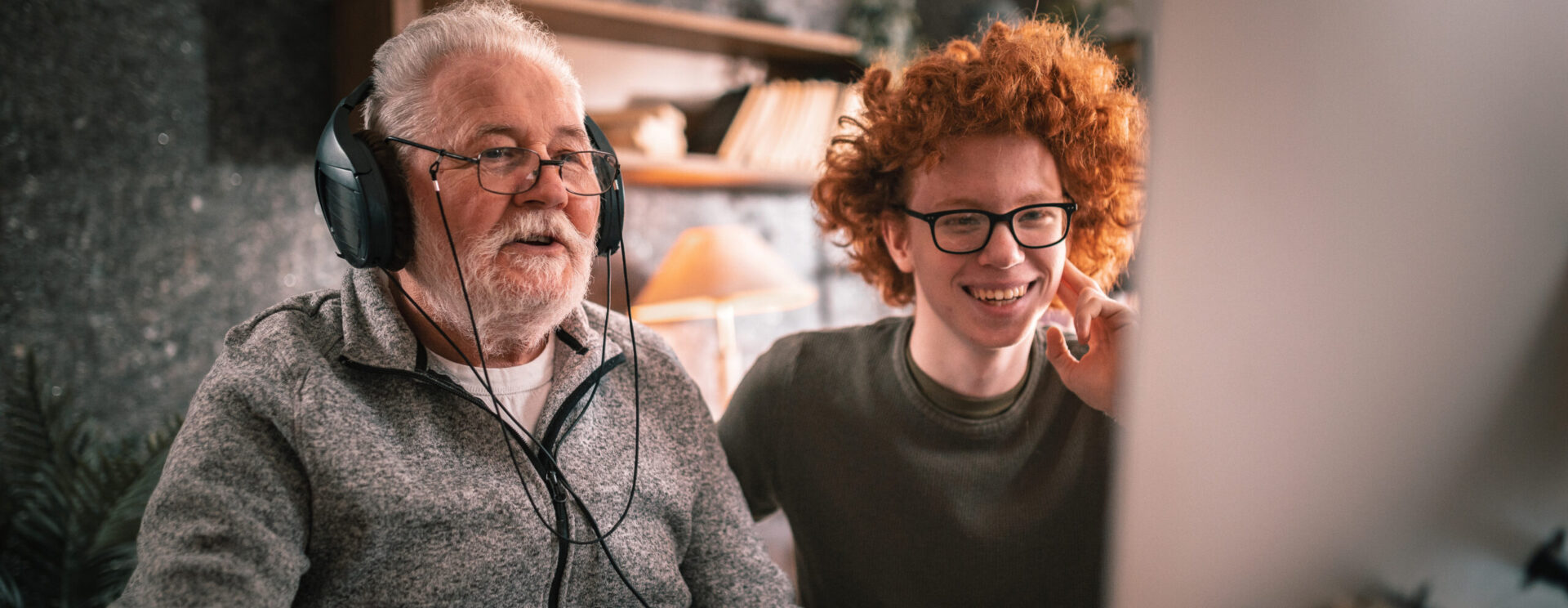 Un grand père et son petit fils devant un ordinateur