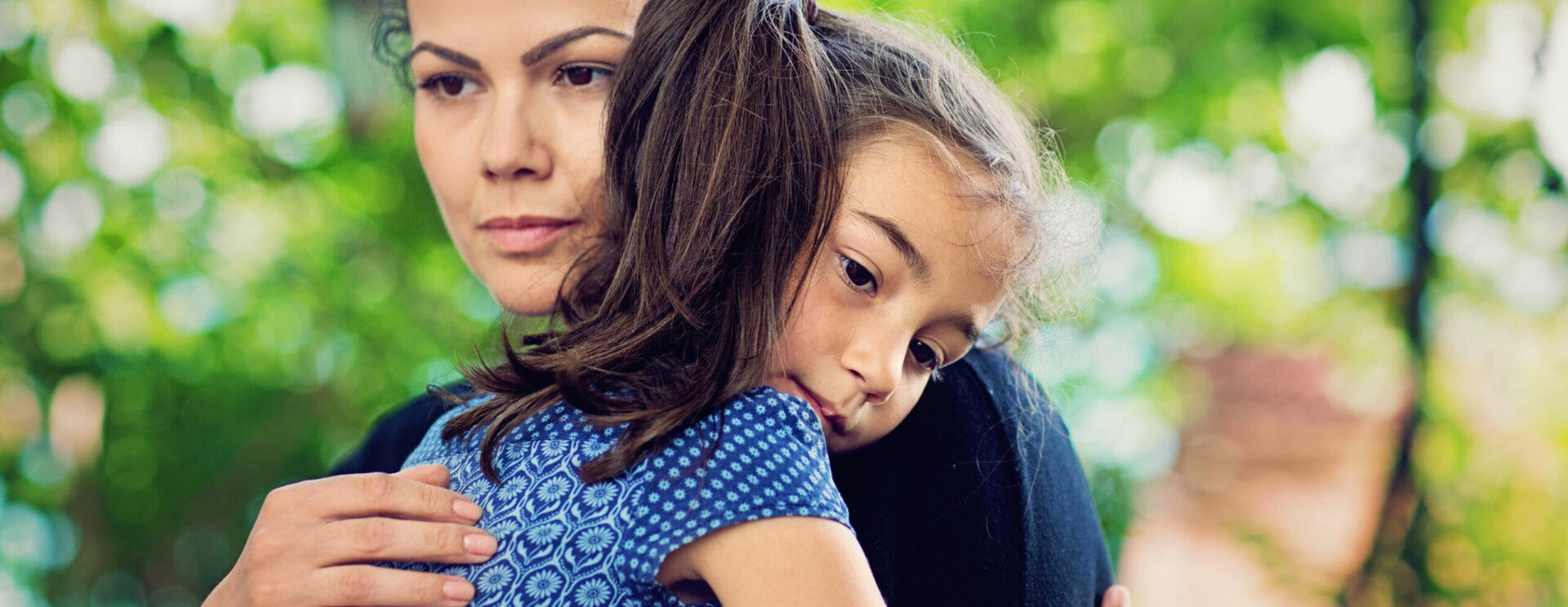 Femme réconfortant une jeune fille dans ses bras