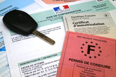 Sur une table un permis de conduire, une carte grise, un avis de contravention et une clé de voiture - Agrandir l'image, fenêtre modale