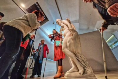 Au centre une sculpture d'une femme nue représentant Léda et Zeus en signe. A son côté Camille, du musée muséum racontant la légende de Léda et Zeus. Tout autour des personne malvoyantes ou aveugles écoutant les explications. - Agrandir l'image 1 sur 13, fenêtre modale