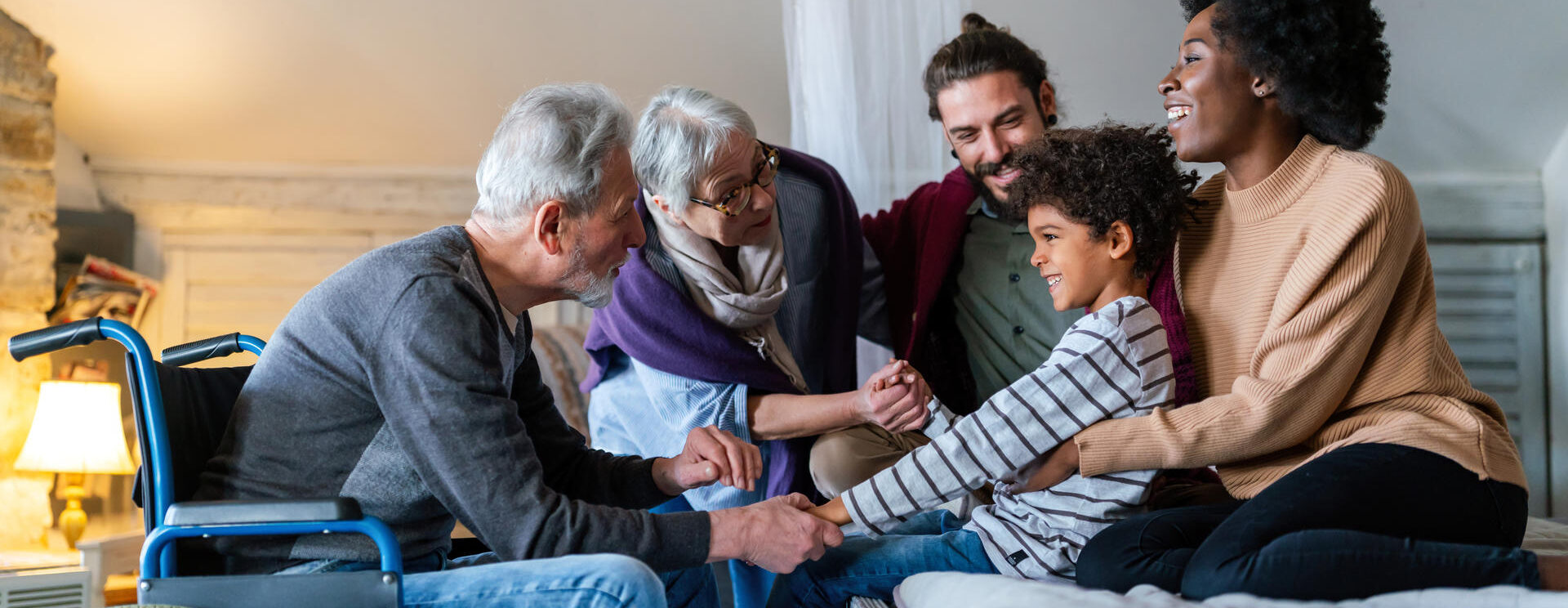 Grand père en fauteuil roulant entouré de sa famille