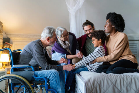Grand père en fauteuil roulant entouré de sa famille