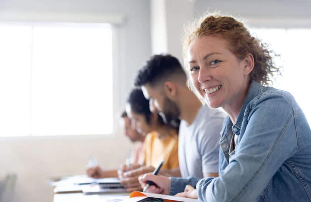 Groupe de personnes lors d'une formation. Une femme souriante regarde l'objectif - Agrandir l'image, fenêtre modale