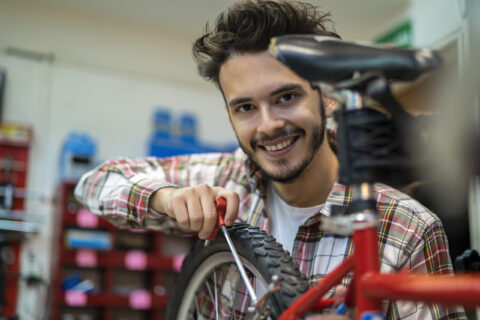 Jeune homme réparant un vélo