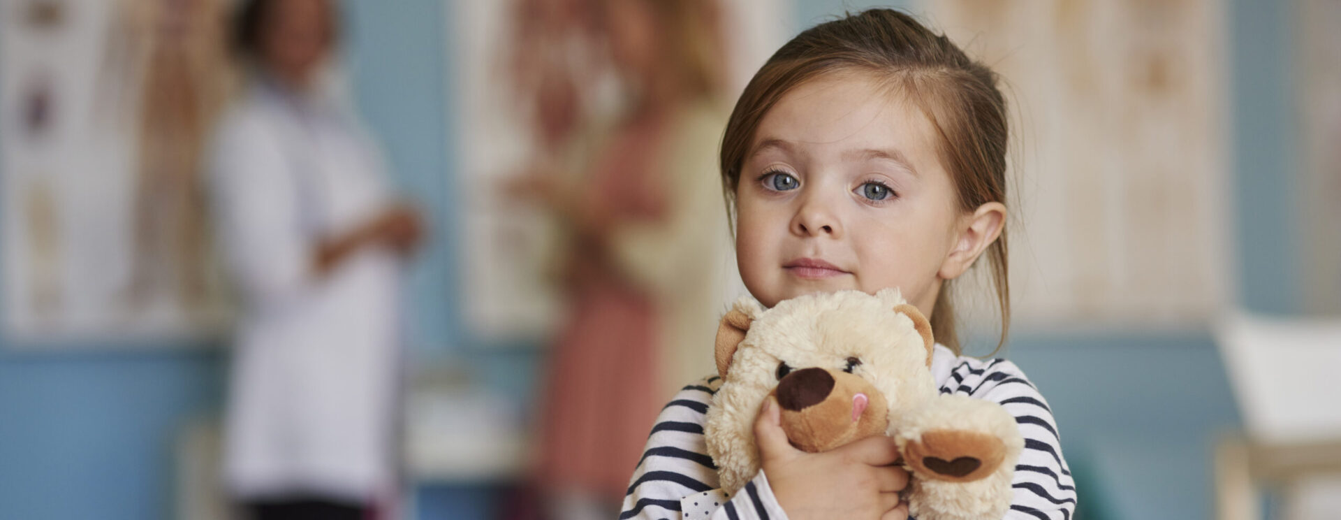 Jeune fille tenant son ours en peluche contre elle