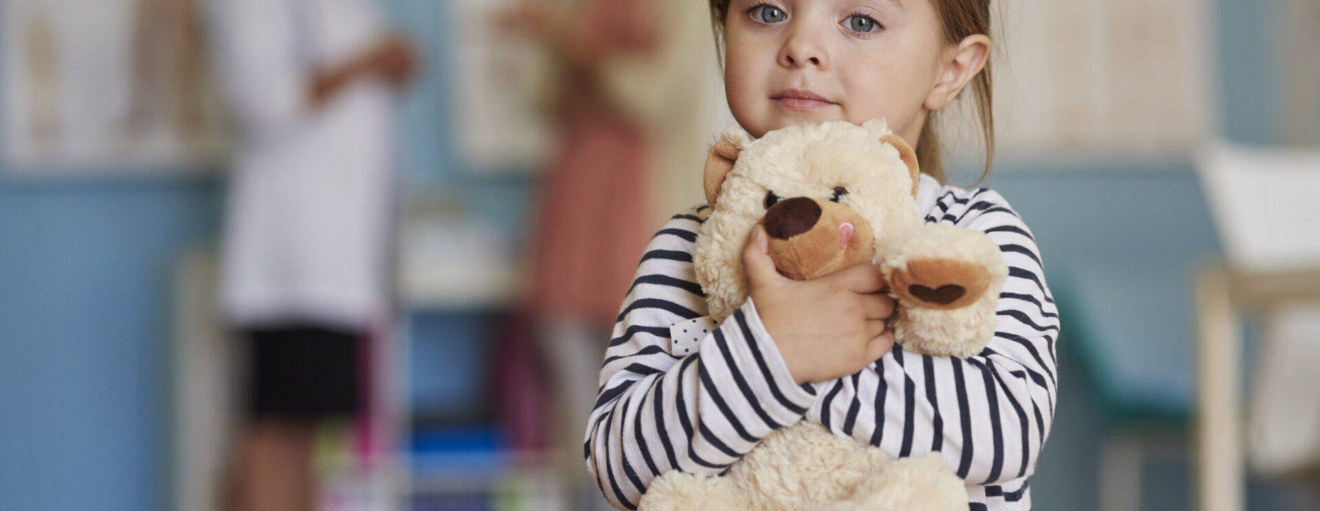 Jeune fille tenant son ours en peluche contre elle