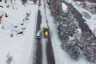 Une voiture double un chasse-neige en intervention sur une route enneigée - Agrandir l'image, fenêtre modale