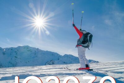 Un skieur lève les bras (et ses batons) au ciel il regarde vers la montagne en fac. En bas de l'image on lit 2030 - Agrandir l'image 8 sur 12, fenêtre modale