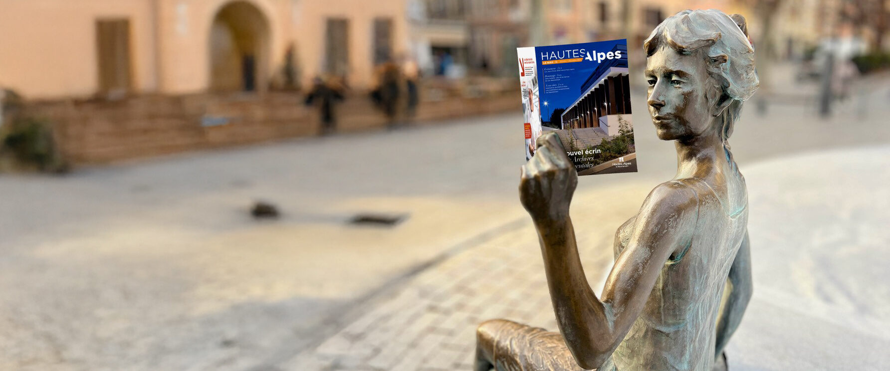 Montage photo de la statue "La liseuse" à Gap lisant un exemplaire du Magazine départemental