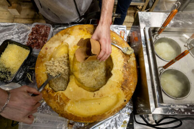 Personne qui sert des pâtes mélangées dans une grosse meule de fromage - Agrandir l'image 16 sur 19, fenêtre modale