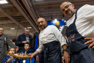 Deux hommes de département des hautes-alpes qui servent du fromage et du jambon au public du salon de l'agriculture - Agrandir l'image 15 sur 19, fenêtre modale