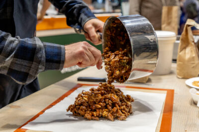 Personne qui verse sur une feuille de papier des amandes enrobées - Agrandir l'image 13 sur 19, fenêtre modale