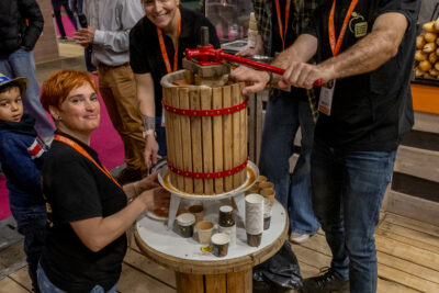 Groupe de producteurs de pomme autour d'un presse-pomme qui sert à faire du jus au salon de l'agriculture - Agrandir l'image 8 sur 19, fenêtre modale