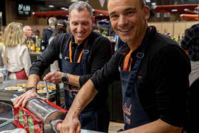 Deux exposants qui remplissent des boyaux pour faire des saucisses au salon de l'agriculture - Agrandir l'image 6 sur 19, fenêtre modale