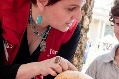 Valerie Delattre, archéo-anthropologue, en train de parler. Un crane humain est en premier plan - Agrandir l'image, fenêtre modale